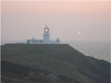 Sun setting at Strumble mimics the light from the lighthouse